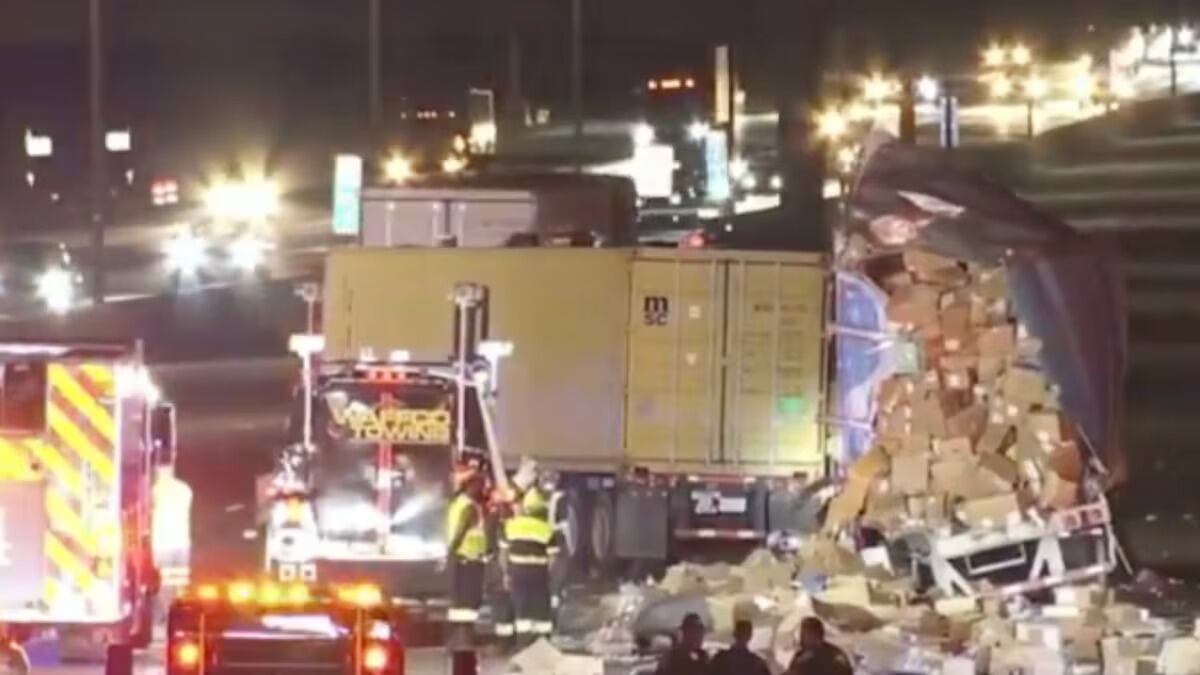 Accidente entre dos camiones deja un conductor grave y cientos de paquetes regados en autopista