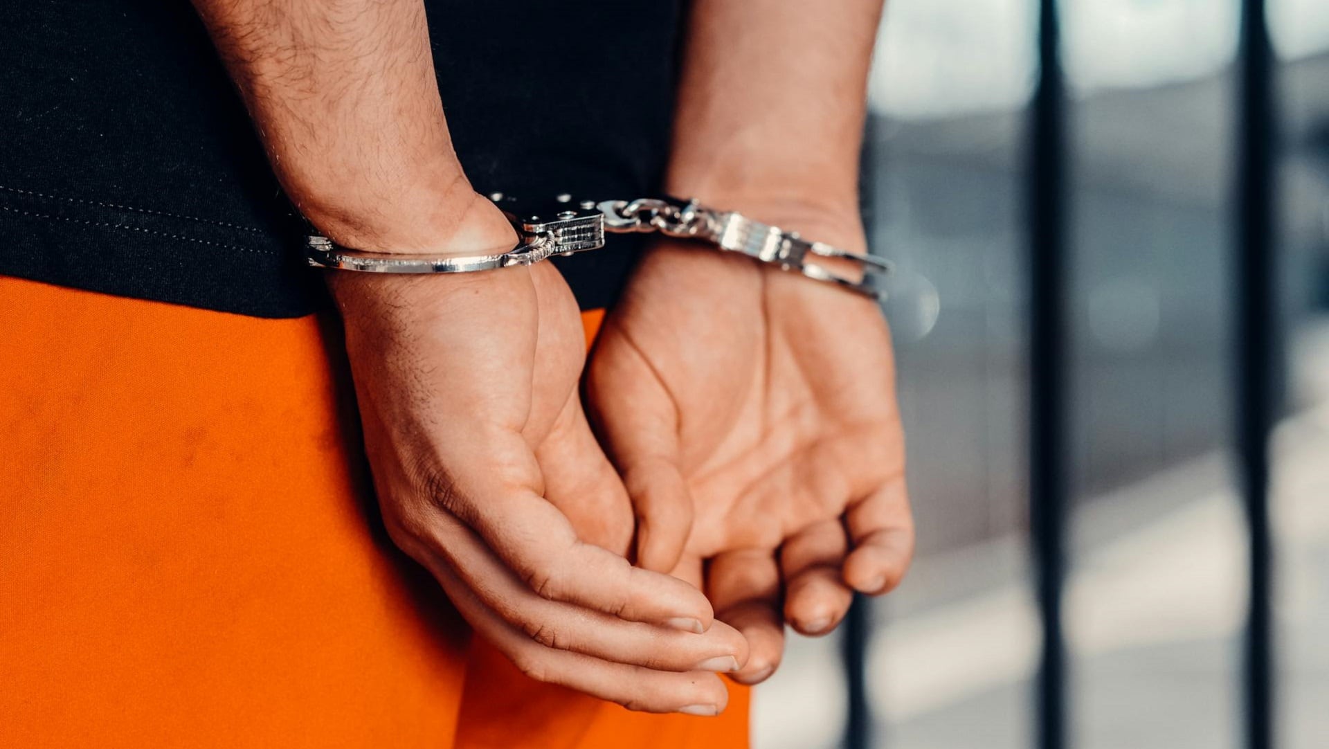 Hombre esposado en prisión